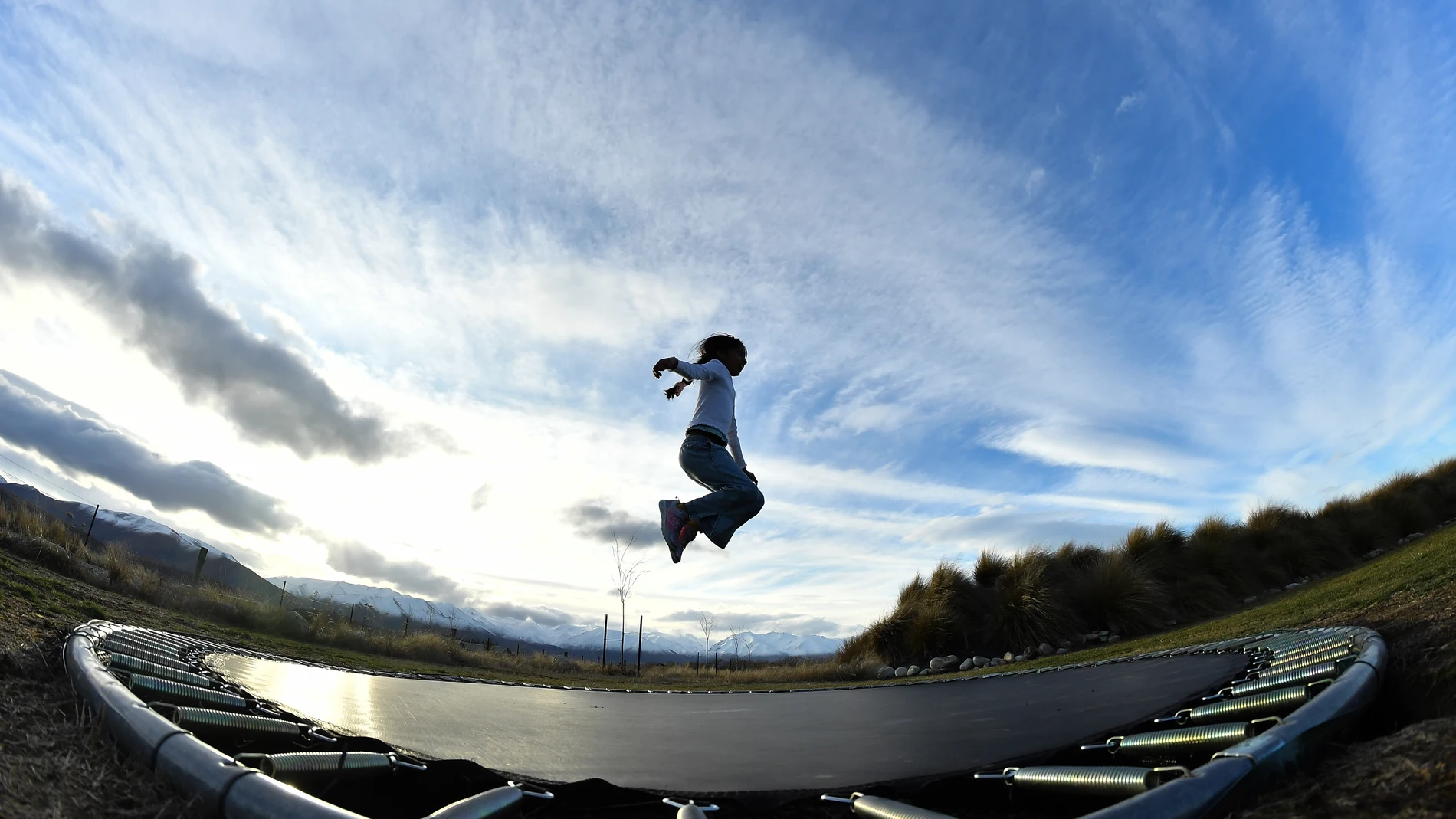 Imagen de archivo de una niña saltando en una cama elástica. Imagen de archivo de una niña saltando en una cama elástica.