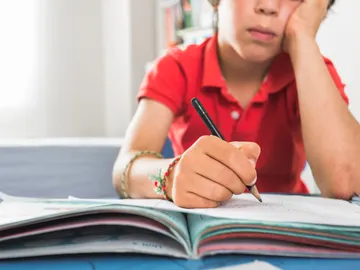 Niño haciendo deberes sin ganas Niño haciendo deberes sin ganas