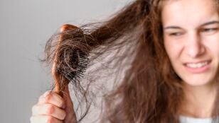 Mujer peinando un pelo con frizz