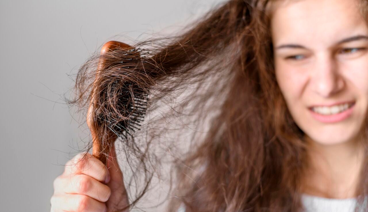 Mujer peinando un pelo con frizz