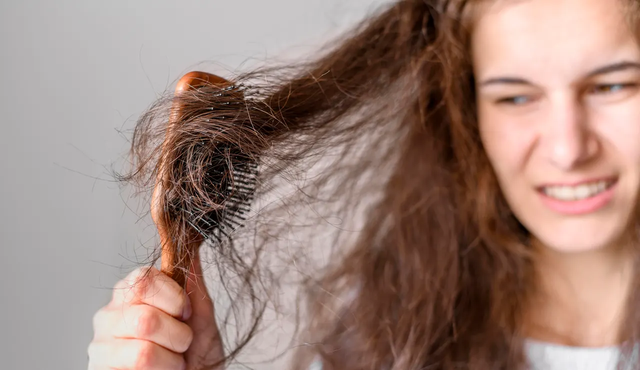 Mujer peinando un pelo con frizz
