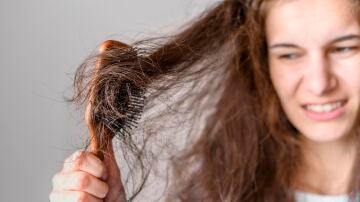 Mujer peinando un pelo con frizz