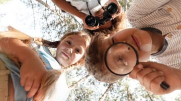 Niños y niñas con lupas y prismáticos 