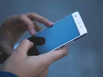 Imagen de archivo de una persona que utiliza su teléfono móvil. Imagen de archivo de una persona que utiliza su teléfono móvil.
