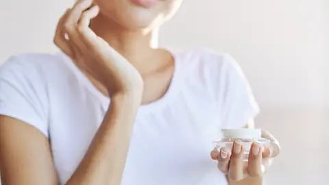 Mujer aplicándose cosmético Mujer aplicándose cosmético