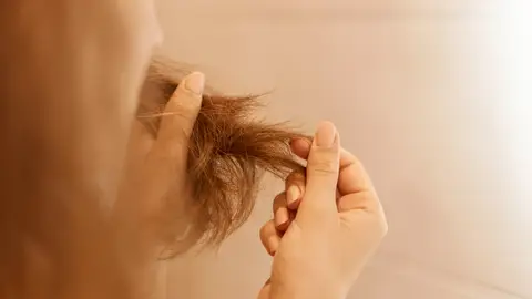 Mujer con el cabello dañado Mujer con el cabello dañado
