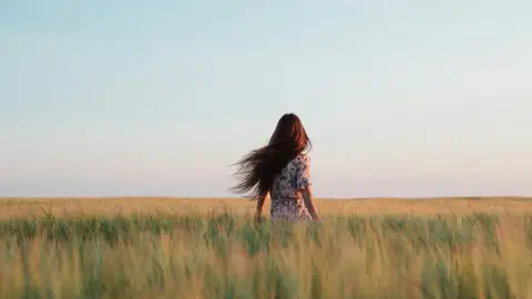 Mujer con cabello largo paseando por el campo Mujer con cabello largo paseando por el campo