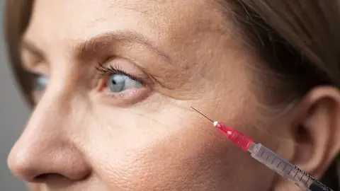 Mujer haciéndose un retoque estético Mujer haciéndose un retoque estético