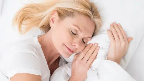 Mujer durmiendo en sábanas de algodón Mujer durmiendo en sábanas de algodón