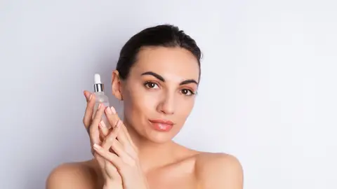 Mujer con un cosmético en la mano Mujer con un cosmético en la mano