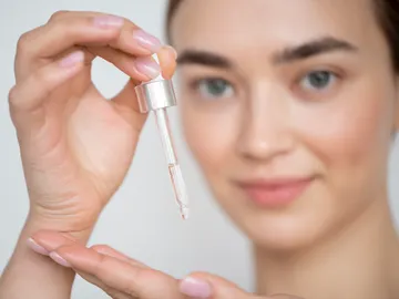 Mujer sujetando un cosmético Mujer sujetando un cosmético