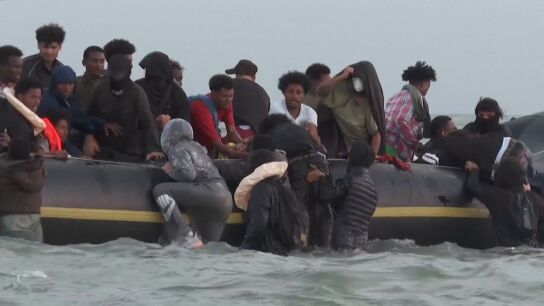 Migrantes intentan subirse a una lancha para cruzar el canal de la Mancha