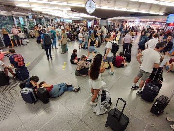 Cientos de personas esperan la salida de su tren en la estación de Atocha en Madrid