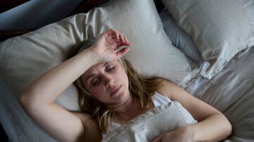 Mujer en la cama sin poder dormir