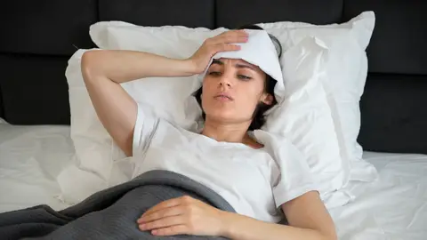 Mujer en la cama con calor Mujer en la cama con calor