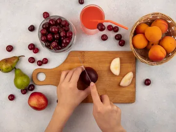 Una persona cortando fruta Una persona cortando fruta