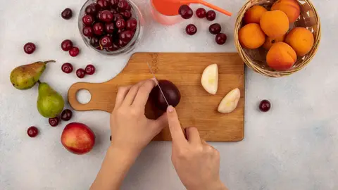 Una persona cortando fruta Una persona cortando fruta