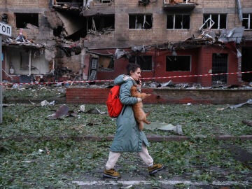 Una mujer con un perro pequeño es evacuada de un edificio residencial de cinco pisos en el distrito de Solomyanskyi, gravemente dañado por un ataque aéreo ruso el 4 de julio de 2025 en Kiev, Ucrania.