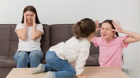Madre saturada frente a sus hijas peleándose Madre saturada frente a sus hijas peleándose