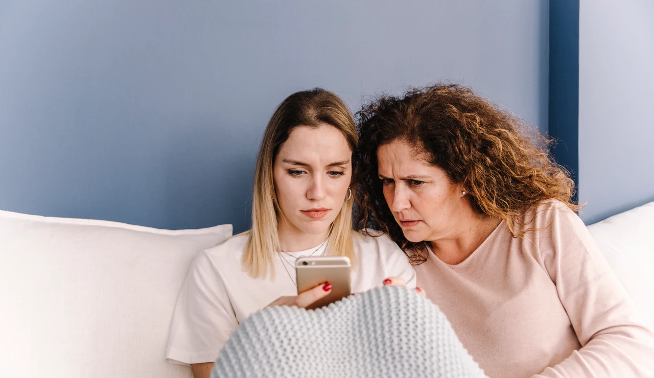 Una madre cotillea el móvil a su hija