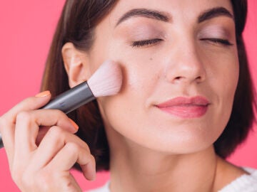 Mujer con una brocha de maquillaje