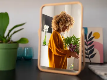 Una mujer ordenando sus plantas en casa Una mujer ordenando sus plantas en casa