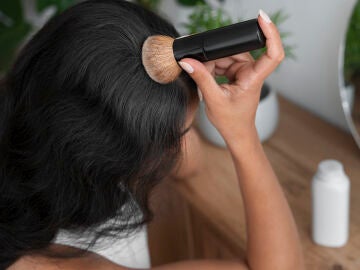 Mujer aplic&aacute;ndose la brocha solar en el cabello