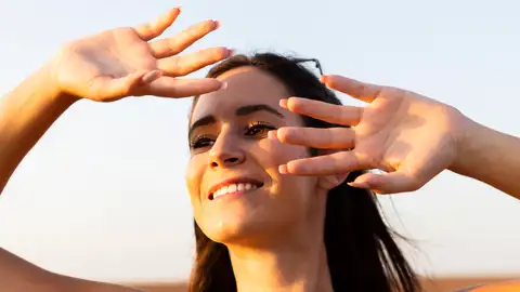 Mujer se protege la cara del sol Mujer se protege la cara del sol