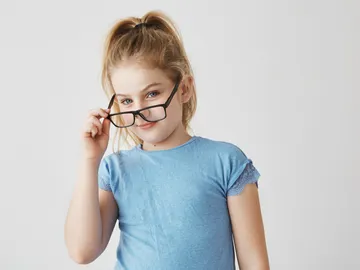 Niña mirado por encima de las gafas Niña mirado por encima de las gafas