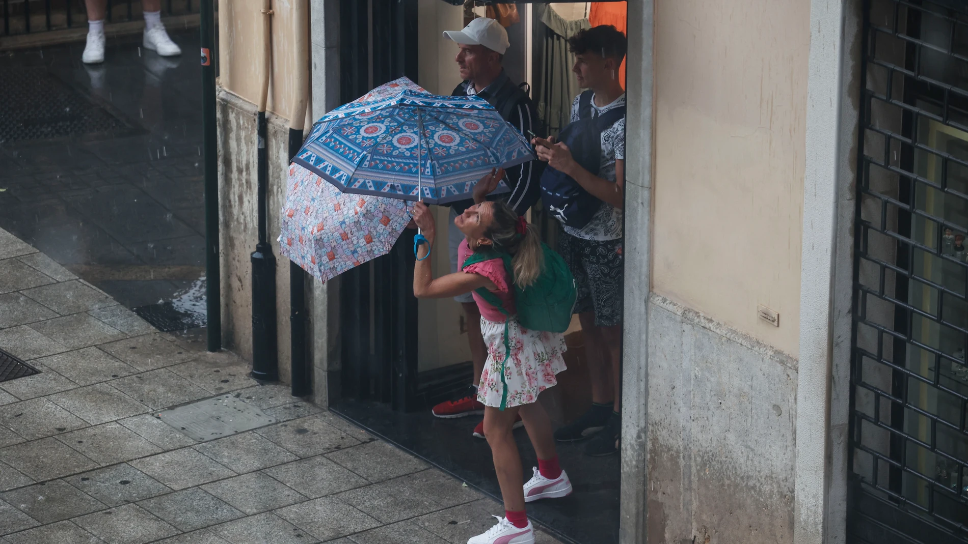 Varias personas se protegen de la lluvia Varias personas se protegen de la lluvia
