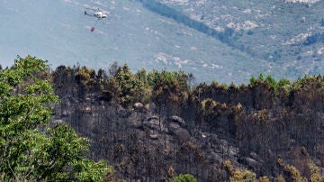 Un helicóptero trata de controlar el fuego en Mombentrán, Ávila