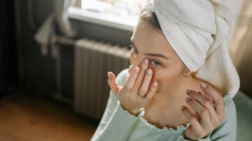 Mujer joven cuidándose el rostro