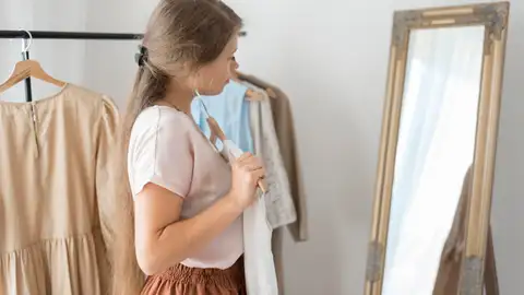 Mujer decidiendo qué ropa se va a poner Mujer decidiendo qué ropa se va a poner