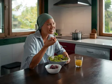 Mujer con cáncer comiendo una ensalada Mujer con cáncer comiendo una ensalada