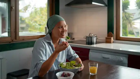 Mujer con cáncer comiendo una ensalada Mujer con cáncer comiendo una ensalada