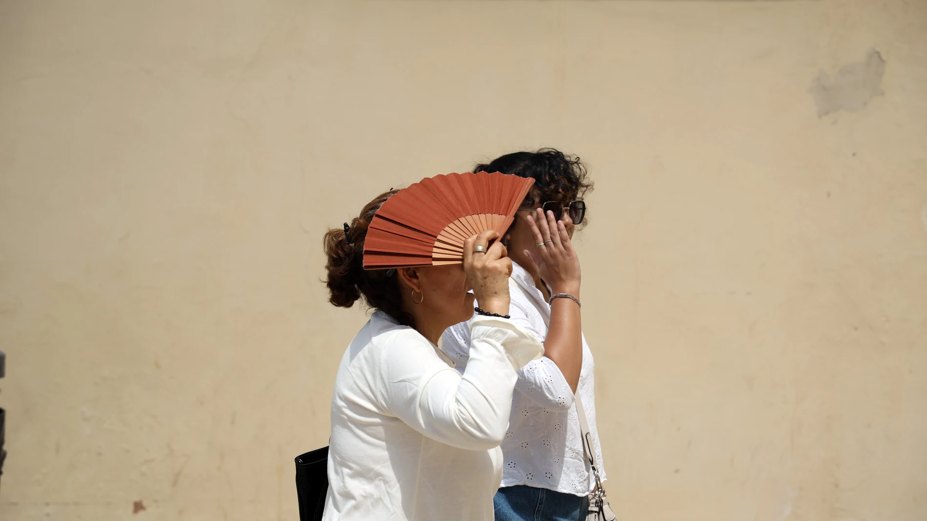 Varias personas se protegen del sol en una calle de Málaga. Varias personas se protegen del sol en una calle de Málaga.