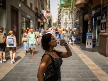 Una mujer bebe agua de una botella en una calle céntrica durante una ola de calor en la ciudad de Santa Cruz de Tenerife, Islas Canarias.