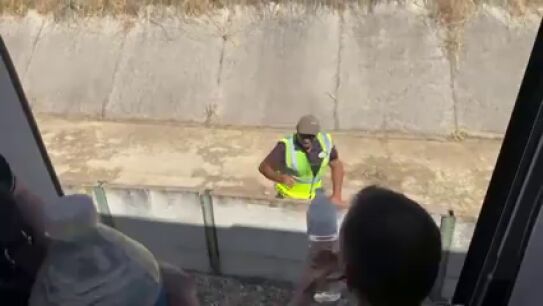 La Guardia Civil y algunos efectivos del equipo de seguridad del tren lanzan botellas de agua a los pasajeros