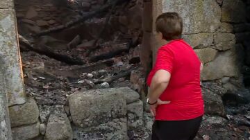 Una vecina contempla su casa destruida