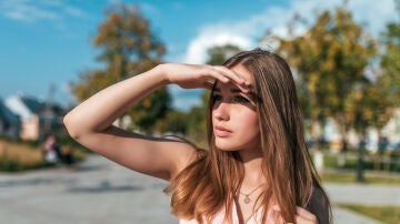Chica tapándose del sol