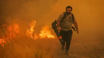 Un vecino intenta mitigar las llamas en Portugal. Un vecino intenta mitigar las llamas en Portugal.