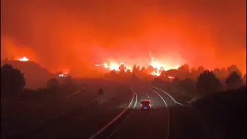 Coche circulando por la A-52 en mitad de los incendios que calcinan Ourense Coche circulando por la A-52 en mitad de los incendios que calcinan Ourense