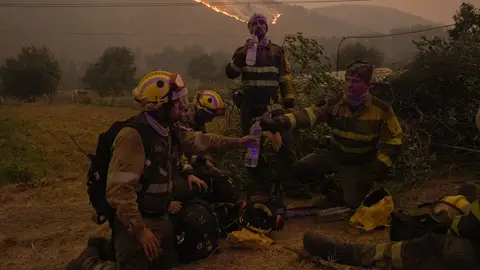 Imagen de bomberos descansando en un incendio Imagen de bomberos descansando en un incendio