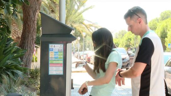 Imagen de dos chicos usando un park&iacute;metro. 