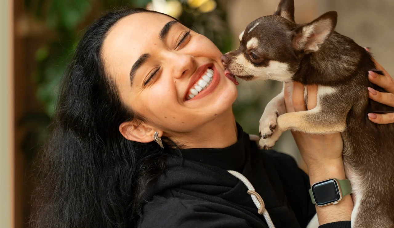 Mujer siendo lamida por su perro