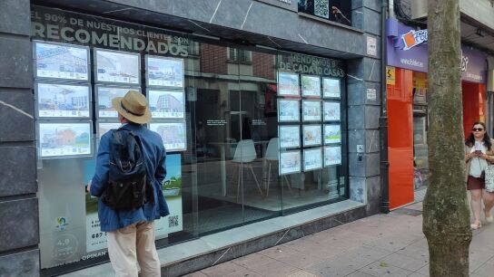 Un hombre mira anuncios en una inmobiliaria. 