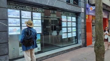 Un hombre mira anuncios en una inmobiliaria. 