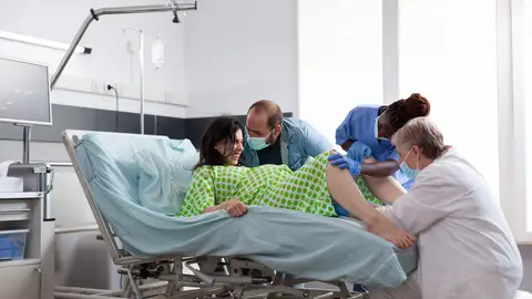 Una mujer en el momento del parto en posición de litotomía. Una mujer en el momento del parto en posición de litotomía.