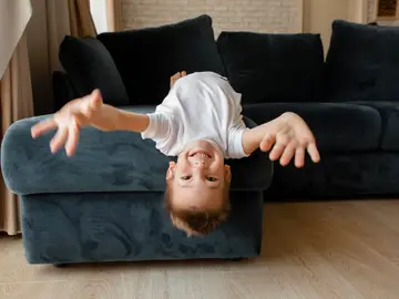 Un niño jugando en el sofá Un niño jugando en el sofá