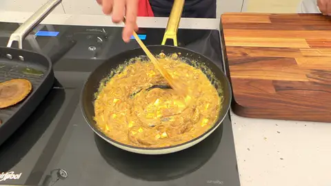 Corta la mitad del queso en dados, añádelos a la sartén y cocina el revuelto Corta la mitad del queso en dados, añádelos a la sartén y cocina el revuelto